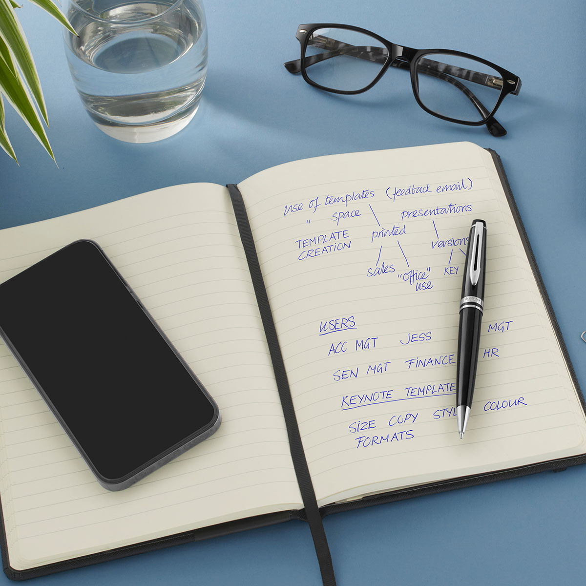 długopis Waterman Expert czarny CT na notesie obok telefonu i okularów