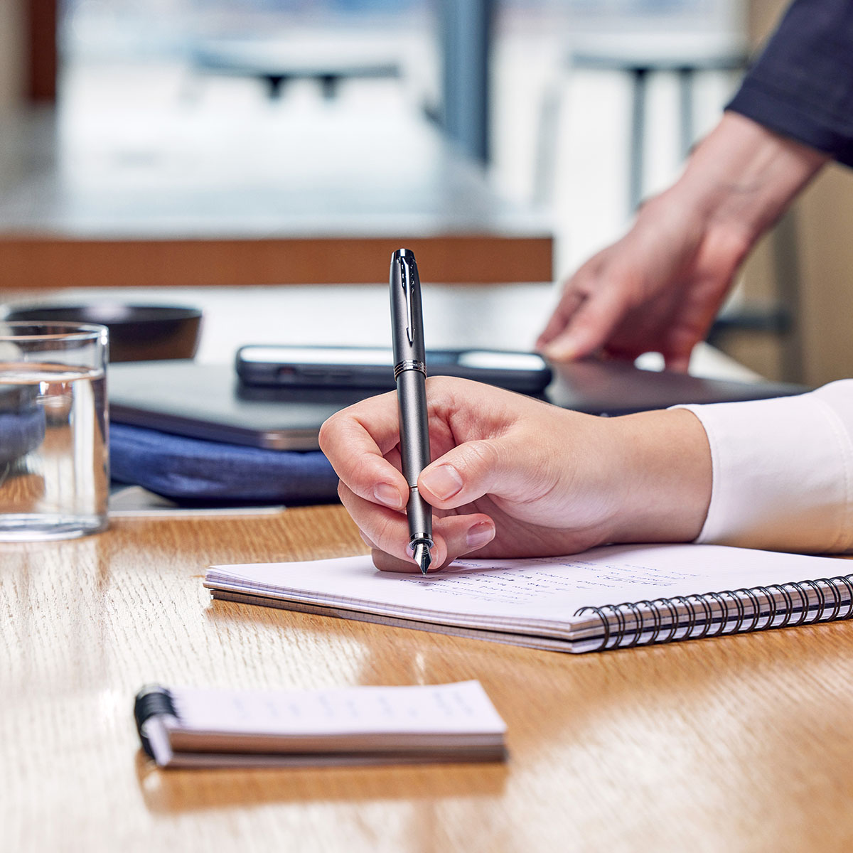 Pióro wieczne Parker IM Monochrome Bronze podczas pisania na notesie spiralnym