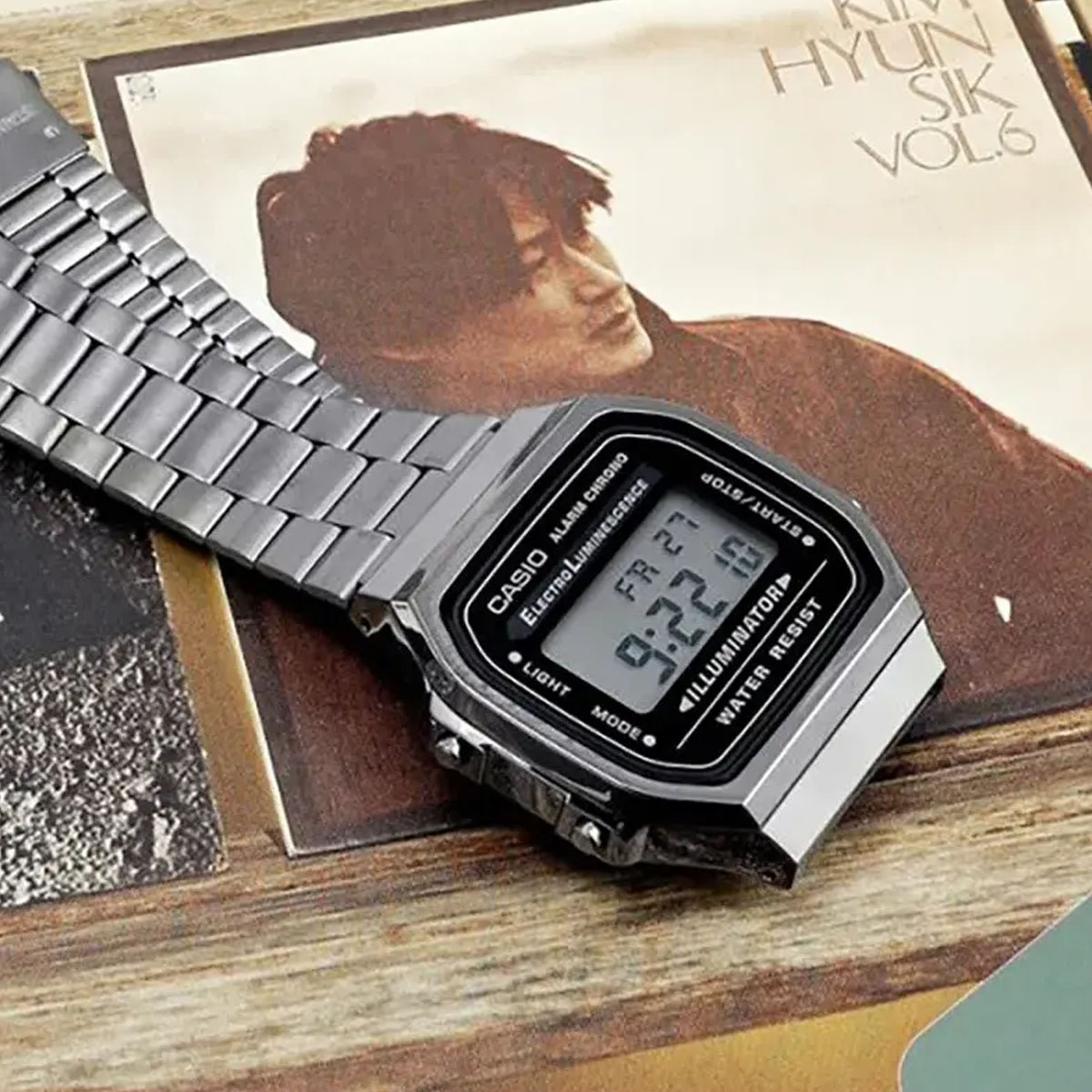 Srebrny zegarek Casio Vintage Illuminator na stalowej bransolecie obok winylowej okładki