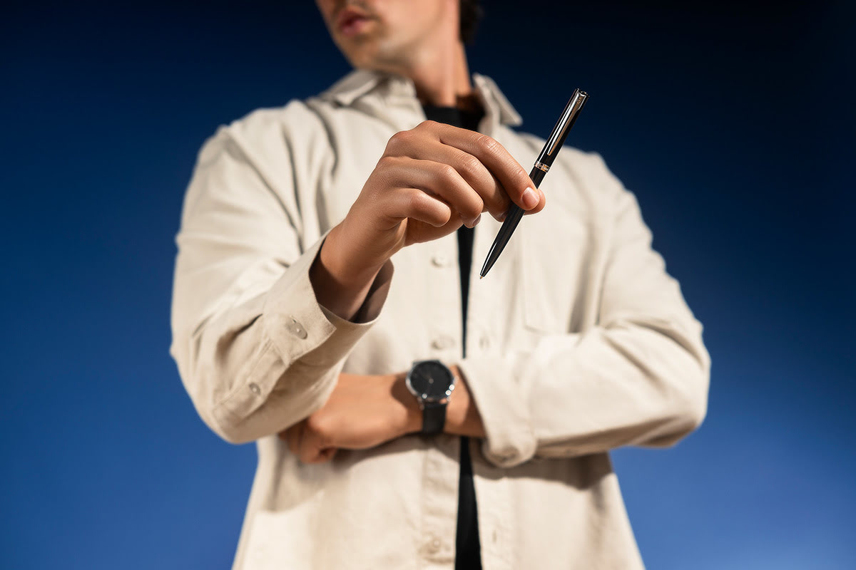 Długopis Waterman Allure Impression czarny CT prezentowany w dłoni na jasnoniebieskim tle