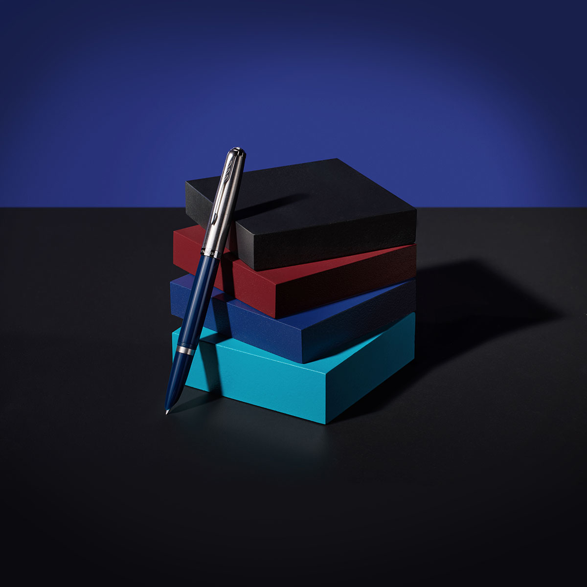 Pióro wieczne Parker 51 midnight blue CT na tle kolorowych pudełek