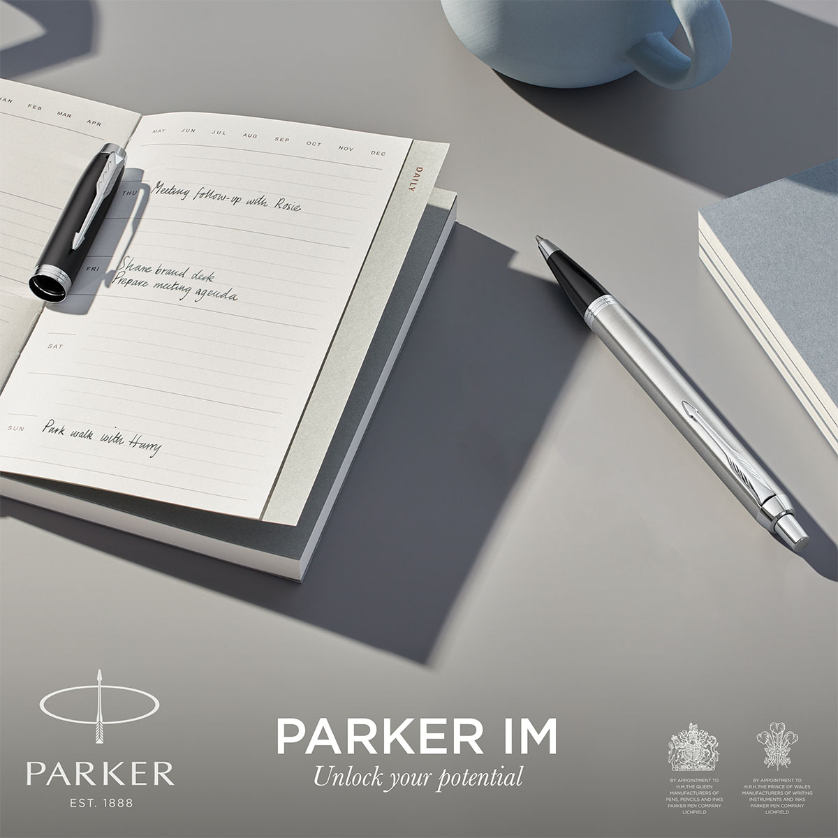 Długopis Parker IM Stainless Steel CT srebrny korpus z chromowanymi detalami obok otwartego notesu