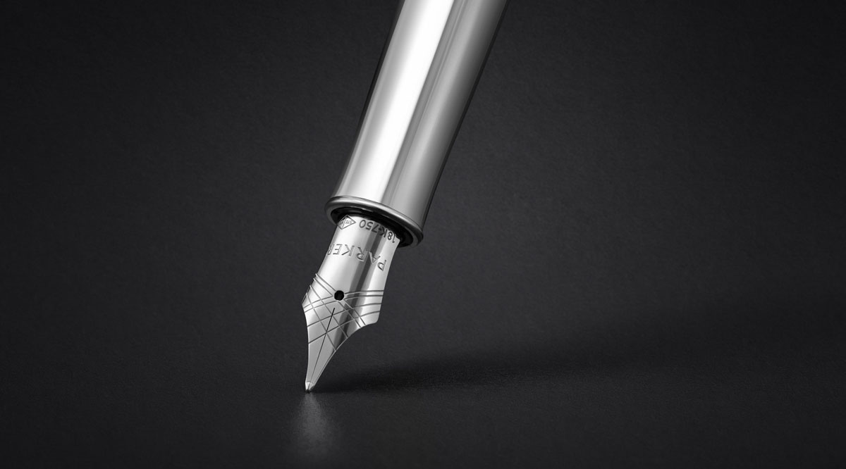 Zbliżenie na stalówkę pióra wiecznego Parker Sonnet z grawerowanym wzorem Ciselé i oznaczeniem 18K-750, na czarnym tle.