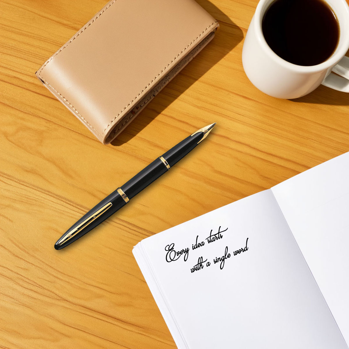 Pióro wieczne Waterman Carene Black Sea GT czarne z złotymi wykończeniami na biurku obok filiżanki kawy i notesu