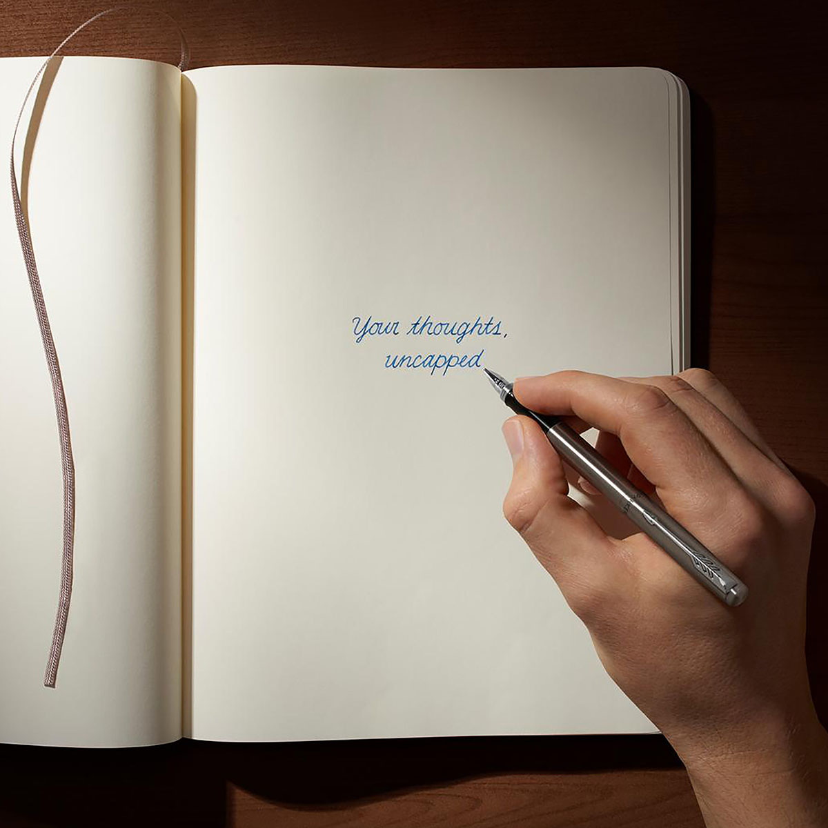 Pióro wieczne Parker Jotter Stalowy CT podczas pisania w otwartym notesie