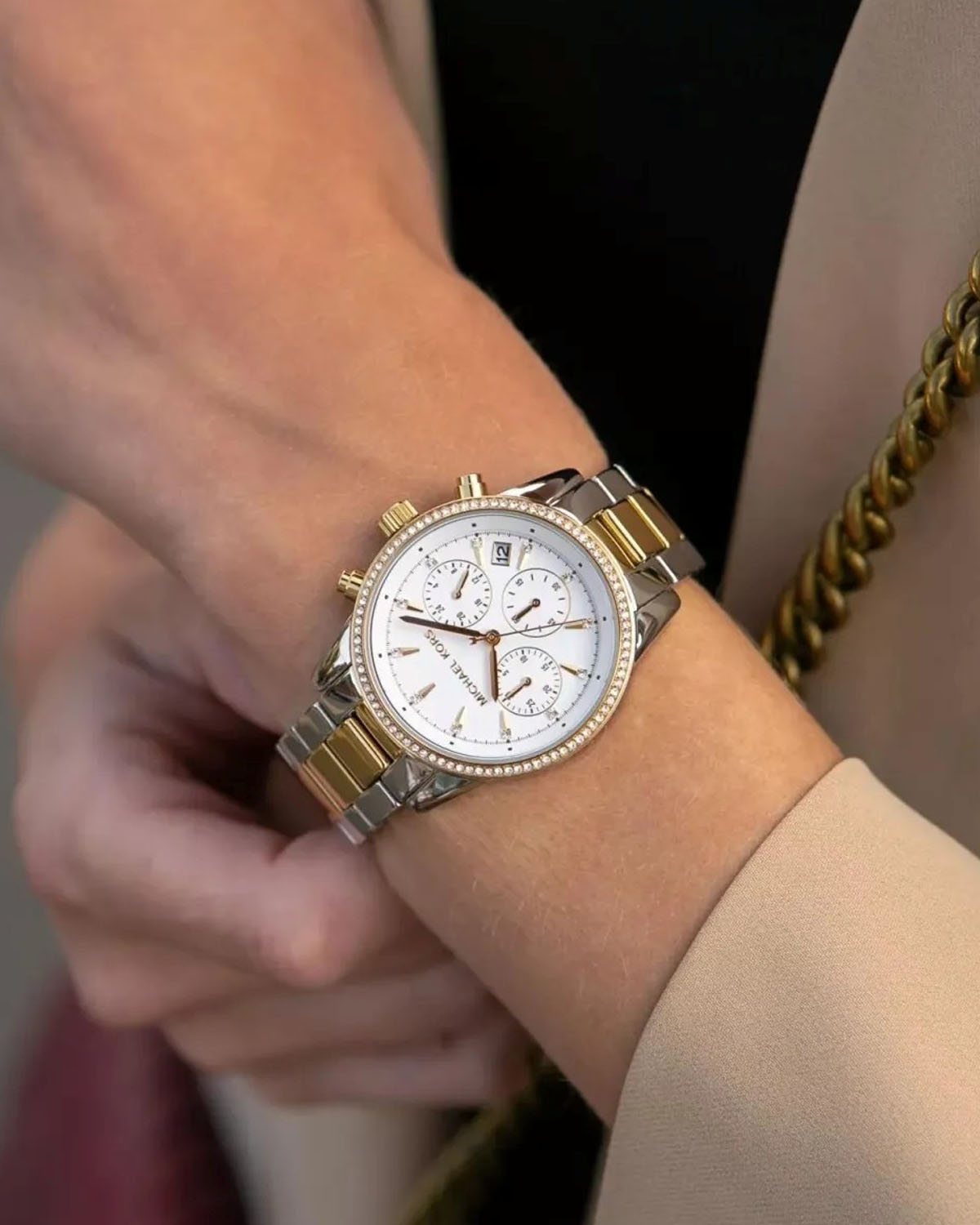 Elegancki damski zegarek Michael Kors w kolorze srebrno-złotym z białą tarczą i bransoletą.