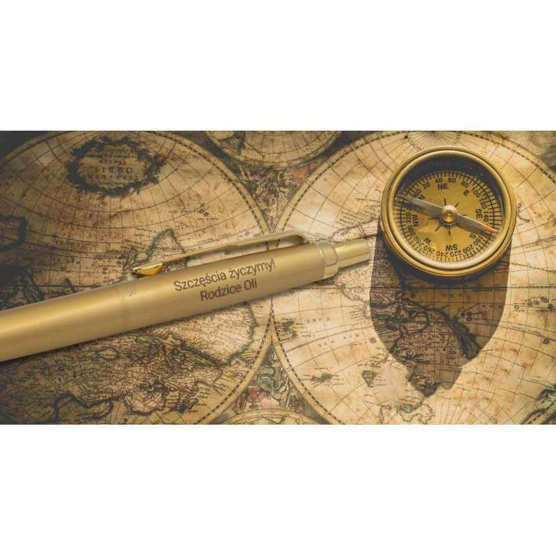 Złoty długopis Parker Jotter XL Monochrome Gold z grawerem „Szczęścia życzymy! Rodzice Oli” na tle mapy świata i złotego kompasu