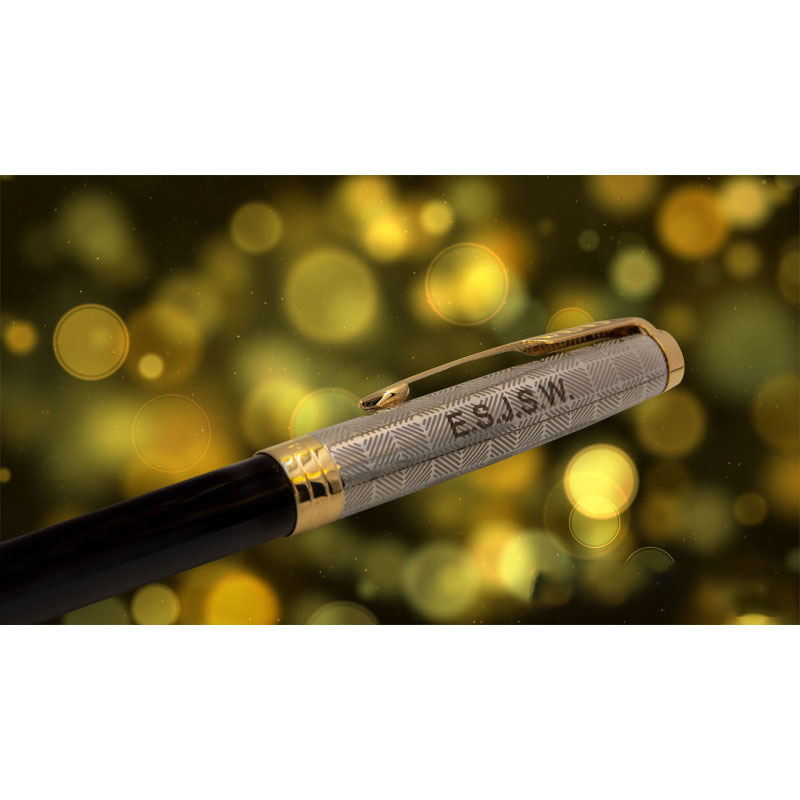 Długopis Parker Sonnet Metal & Black GT z grawerem „ES/JSW” na tle złotych, rozmytych świateł bokeh