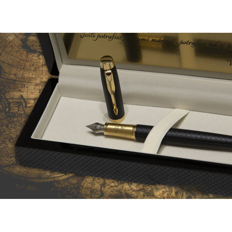 Luksusowe pióro wieczne Parker IM Premium w kolorze czarnym z grawerem inicjałów „G.N.” na złotej obrączce. Korpus pióra pokryty jest eleganckim, geometrycznym wzorem w odcieniu głębokiej czerni, a całość dopełniają złote wykończenia. Produkt zaprezentowa