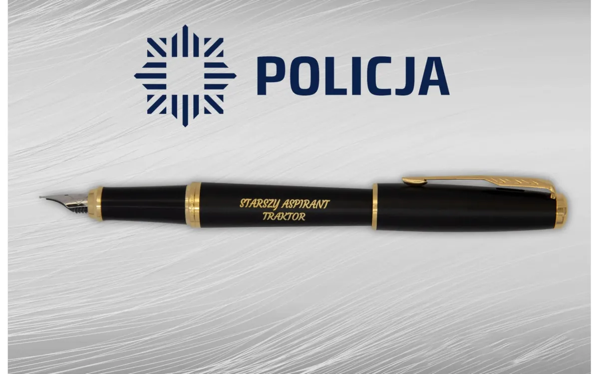 Pi&oacute;ro wieczne Parker Urban Muted Black GT [1931601] &ndash; eleganckie czarne pi&oacute;ro z pozłacanymi wykończeniami, ozdobione grawerem &bdquo;STARSZY ASPIRANT TRAKTOR&rdquo;, zaprezentowane na tle z logo Policji.