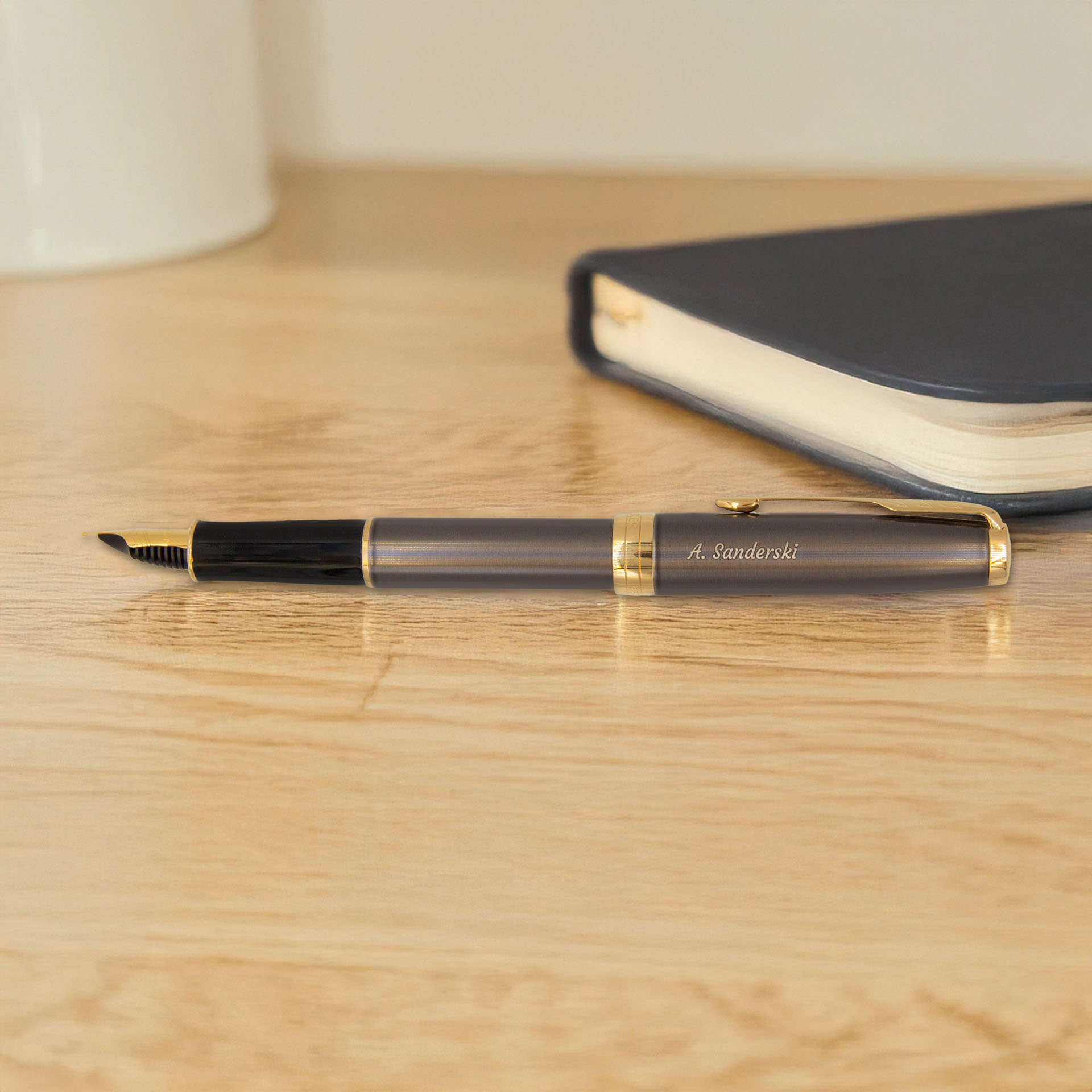 Pióro wieczne Parker Sonnet Grey z pozłacanymi detalami na biurku obok notesu