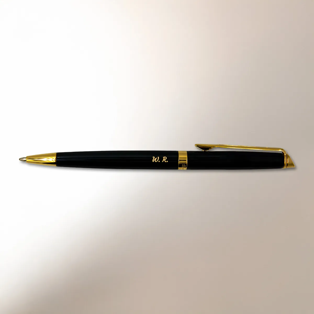 Długopis Waterman Hemisphere czarny GT (S0920670) z pozłacanymi wykończeniami i grawerem inicjałów „W.R.” na jasnym tle z miękkim światłem