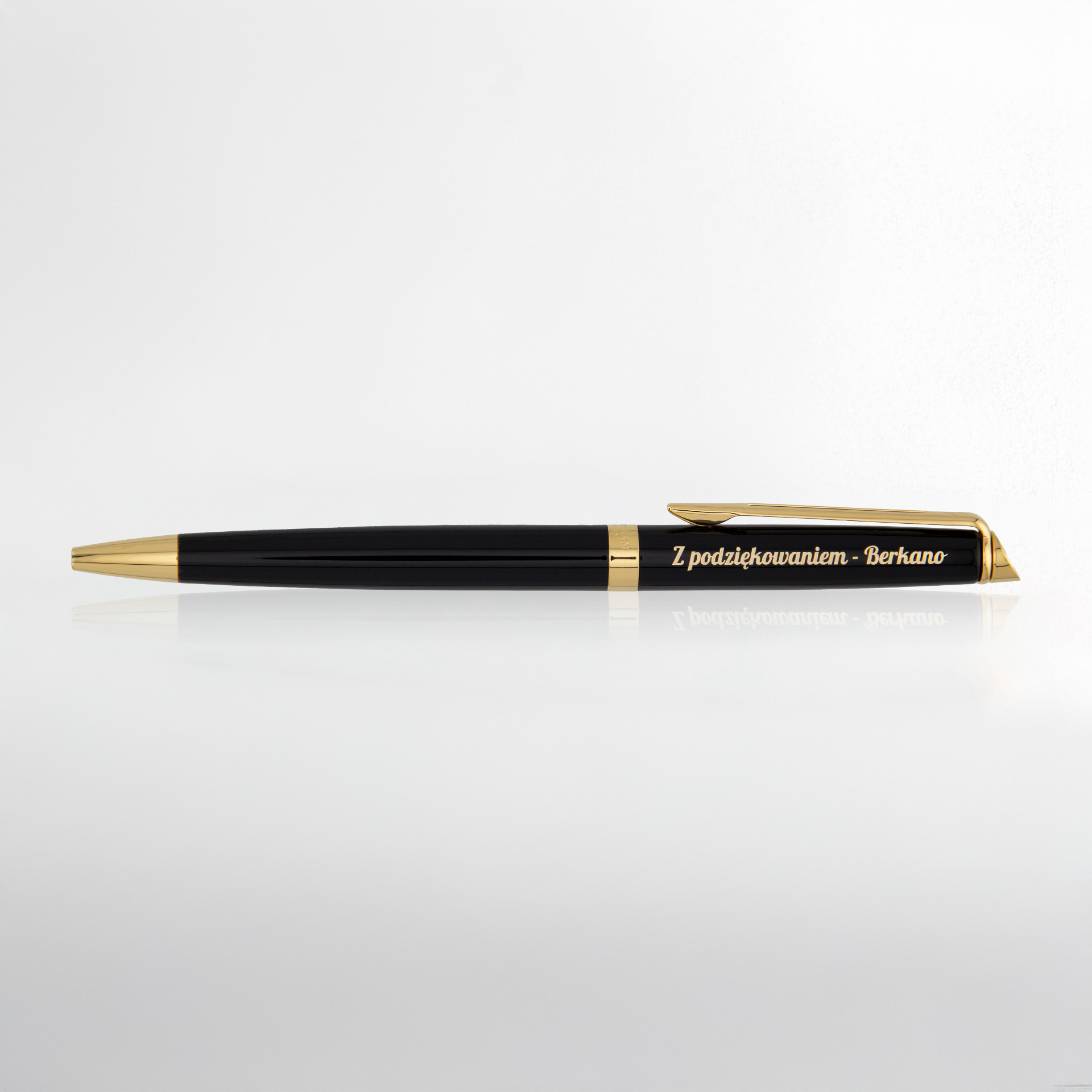 Czarno-złoty długopis z grawerem „Z podziękowaniem – Berkano” na jasnym tle.