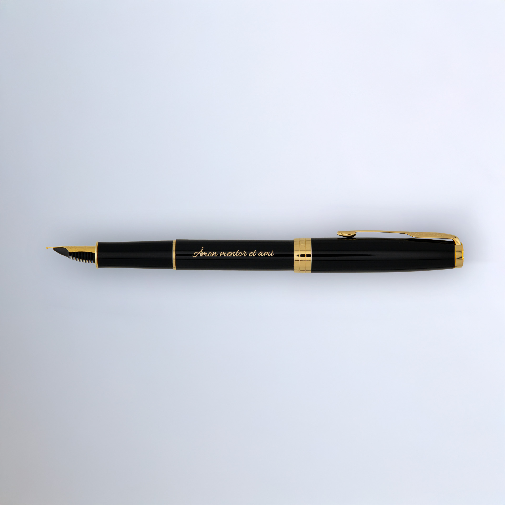 Czarny Parker Sonnet GT z grawerem leży poziomo na jasnym tle, ukazując złote detale i stalówkę.