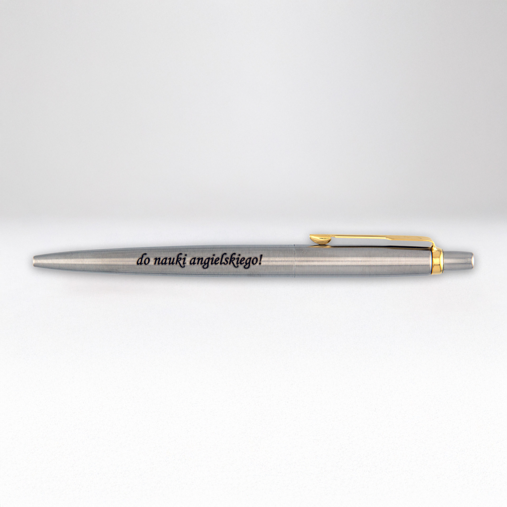 Srebrny metalowy długopis z grawerem „do nauki angielskiego!” i złotym klipsem