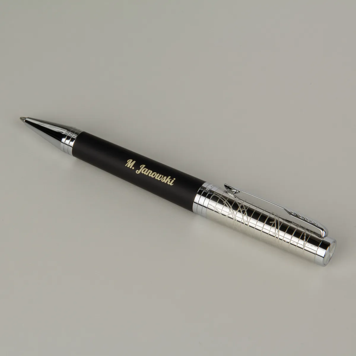 Elegancki czarny długopis z personalizowanym grawerem imienia, srebrne detale, minimalistyczny design premium