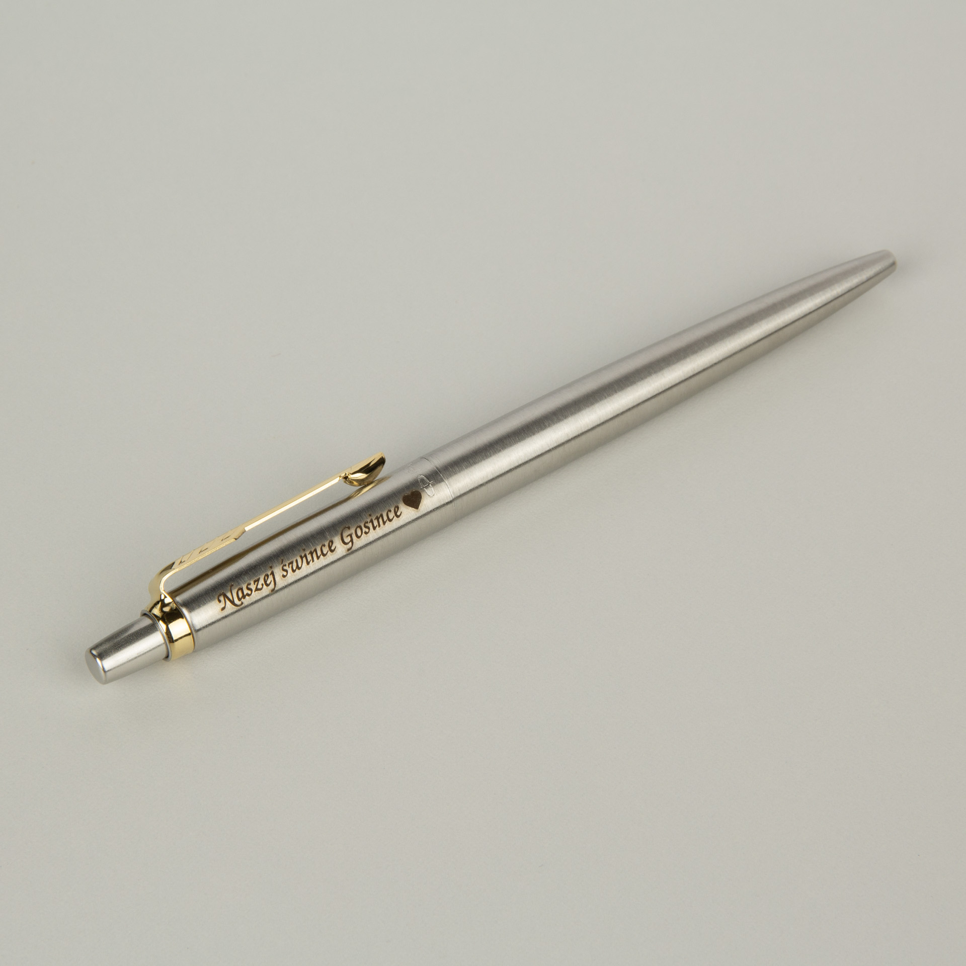 Srebrny długopis z personalizowanym grawerem i złotymi detalami, elegancki prezent premium