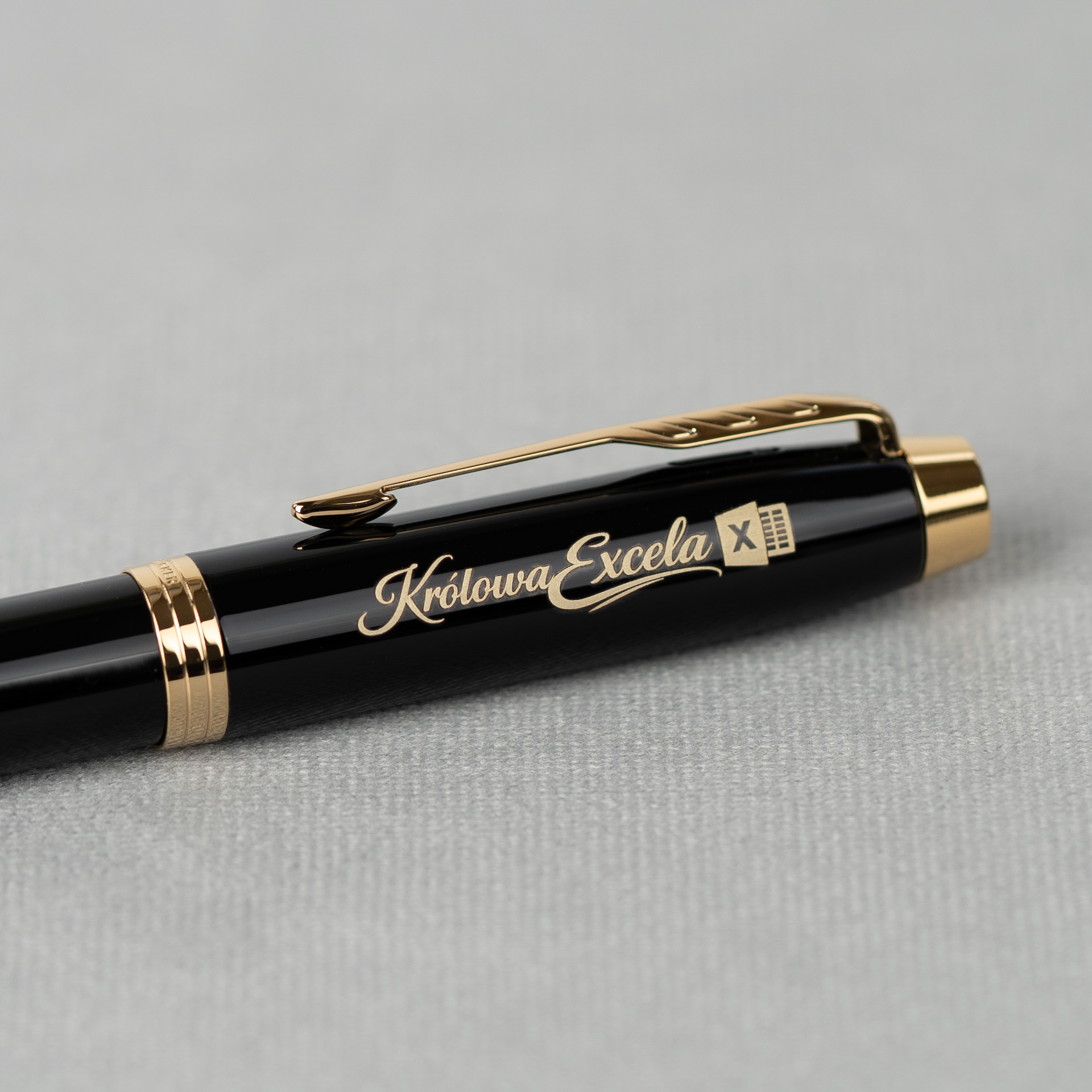 Zbliżenie pióra Parker IM Black GT z personalizowanym grawerem na błyszczącym czarnym korpusie i złotymi detalami