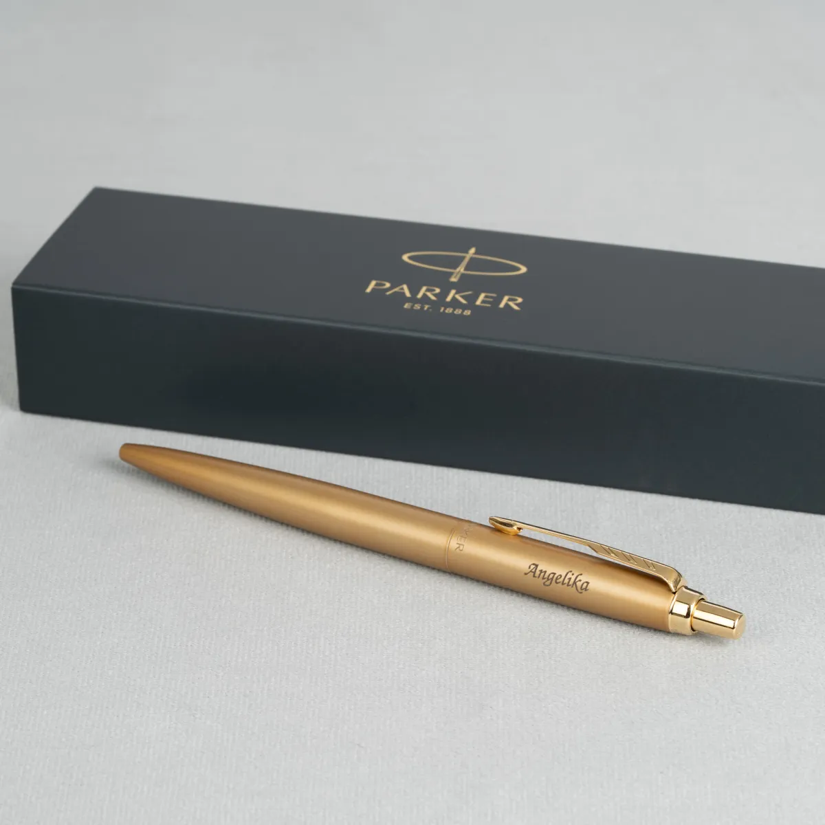Długopis Parker Jotter XL Monochrome Gold z grawerem Angelika na tle pudełka Parker.