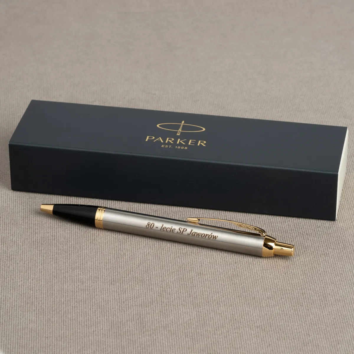 Długopis Parker IM Brushed Metal GT z grawerem „80-lecie SP Jaworów” na tle eleganckiego pudełka Parker.