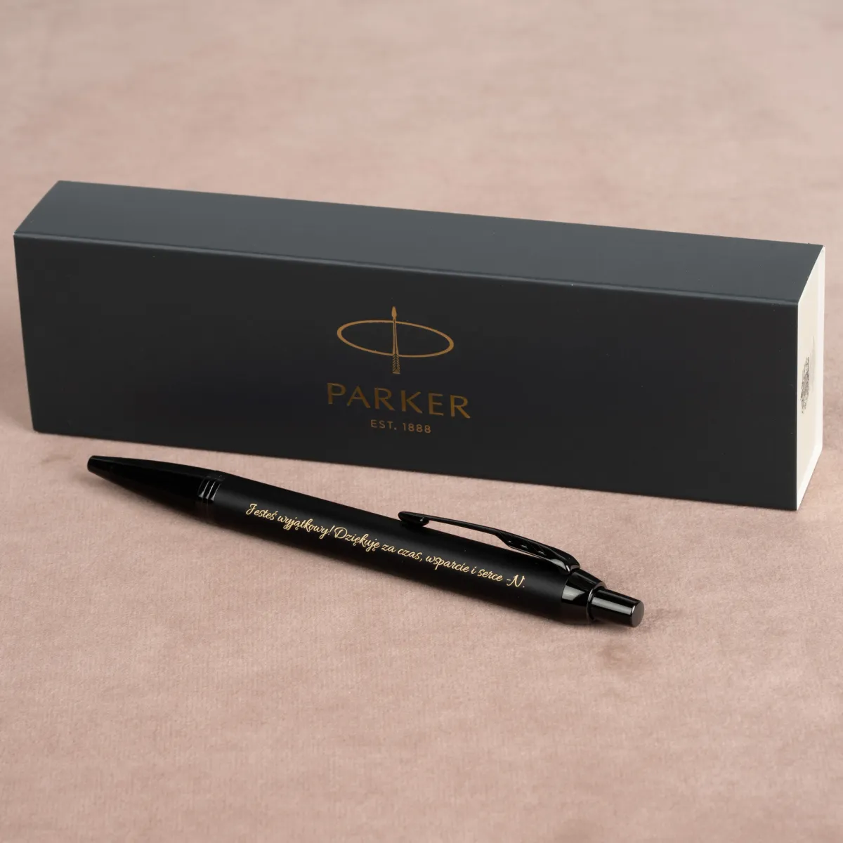 Długopis Parker IM Achromatic Czarny z eleganckim złotym grawerem oraz pudełkiem Parker w tle