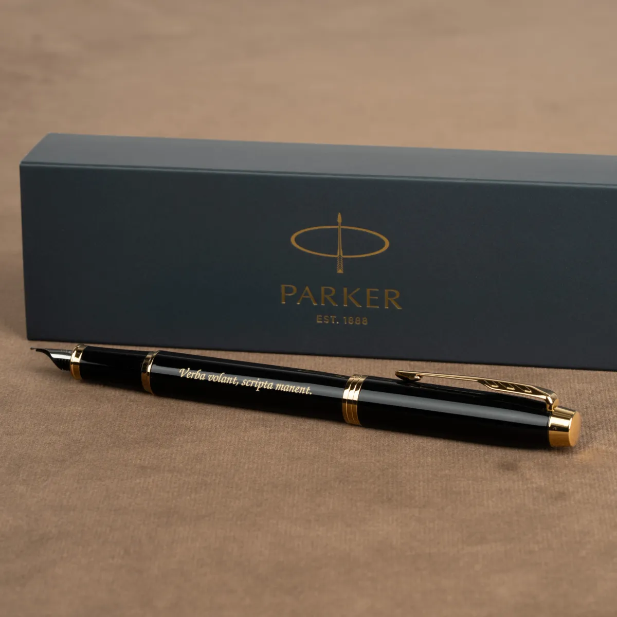 Pióro wieczne Parker IM Czarne GT z grawerem „Verba volant, scripta manent.” na tle eleganckiego pudełka Parker.