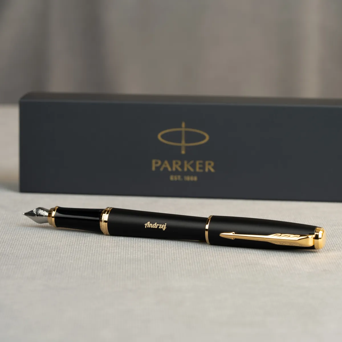 Pióro wieczne Parker Urban Muted Black GT z personalizowanym grawerem imienia „Andrzej” na tle eleganckiego pudełka Parker.