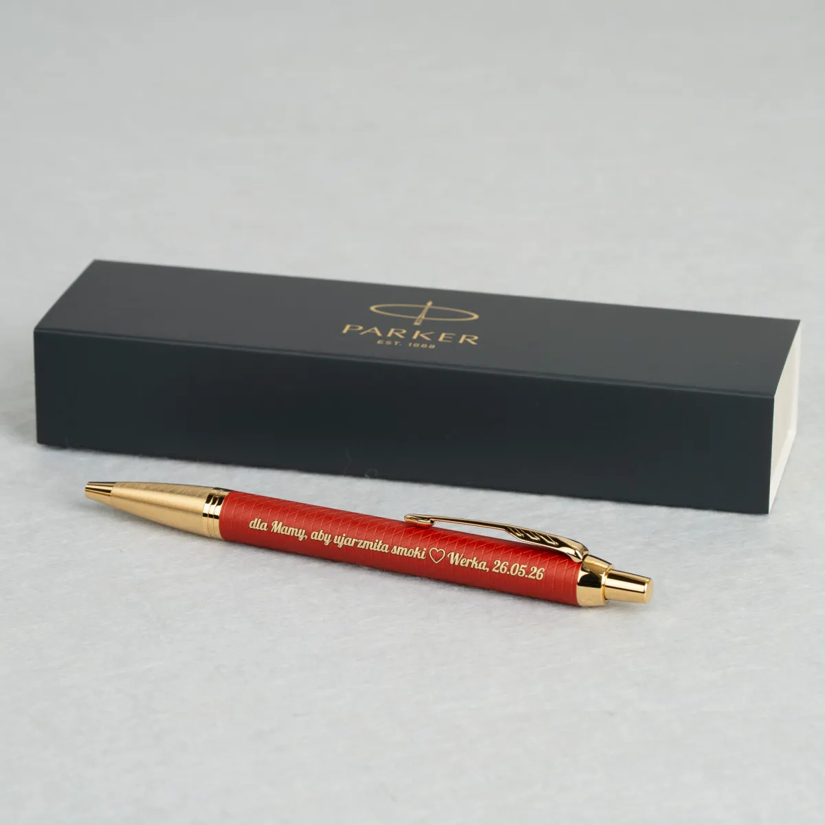 Długopis Parker IM Premium Czerwony GT z personalizowanym grawerem dedykacji dla mamy, prezentowany na tle eleganckiego etui Parker