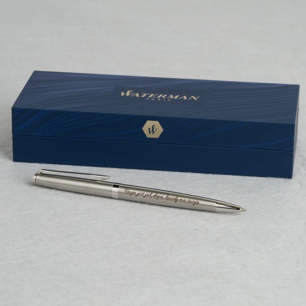 Długopis Waterman Hemisphere stalowy CT z indywidualnym grawerem, prezentowany na tle firmowego etui Waterman.