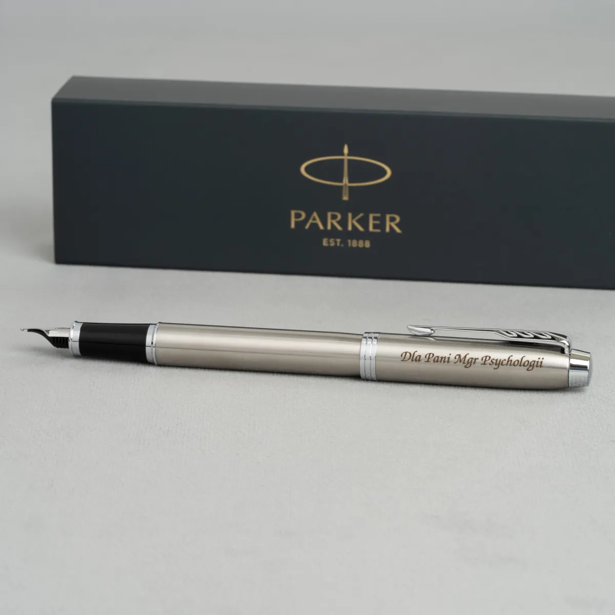 Pi&oacute;ro wieczne Parker IM Stainless Steel CT z grawerem dedykacji, prezentowane na tle firmowego etui Parker.