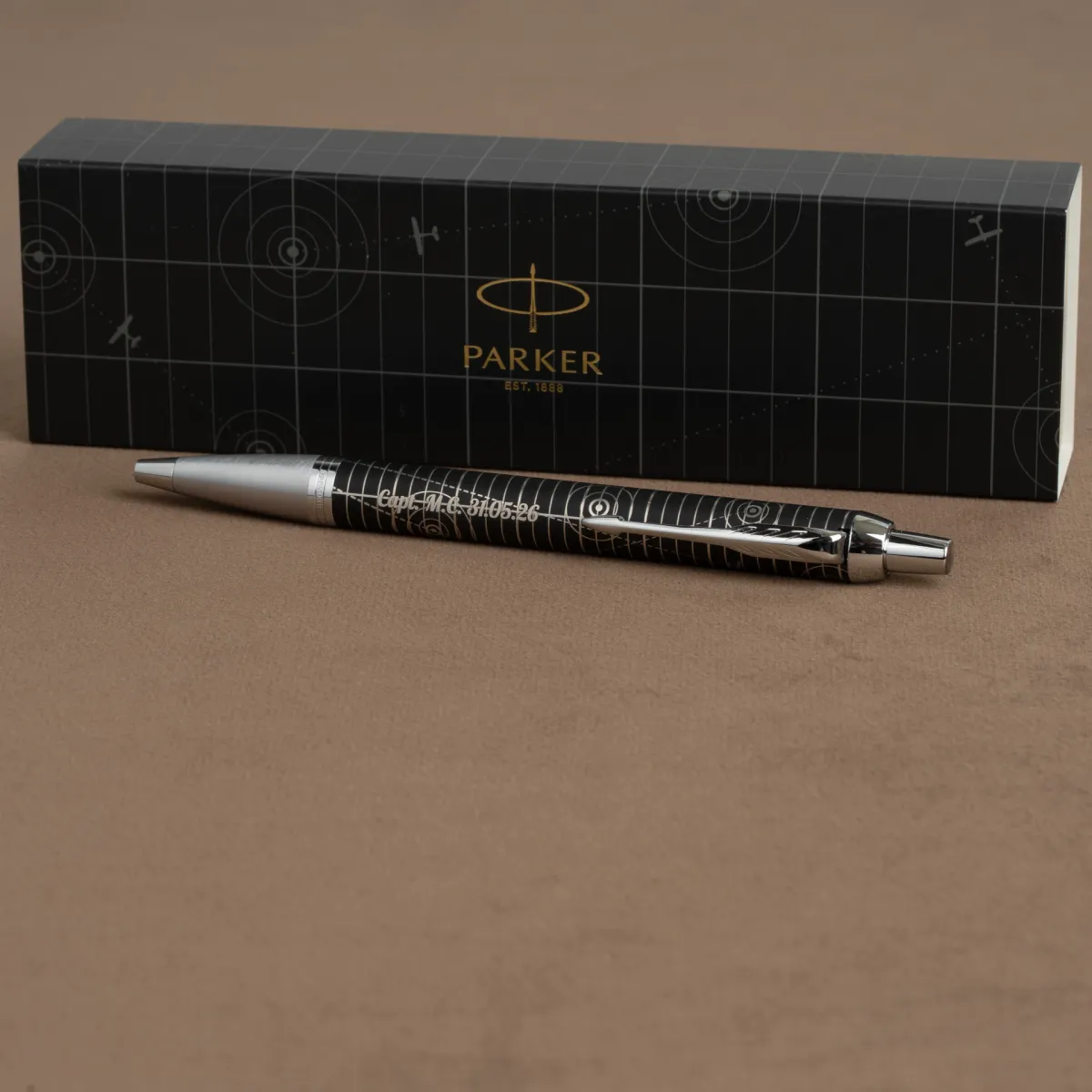 Długopis Parker IM Premium Legacy of Flight CT z grawerem, na tle firmowego etui Parker.