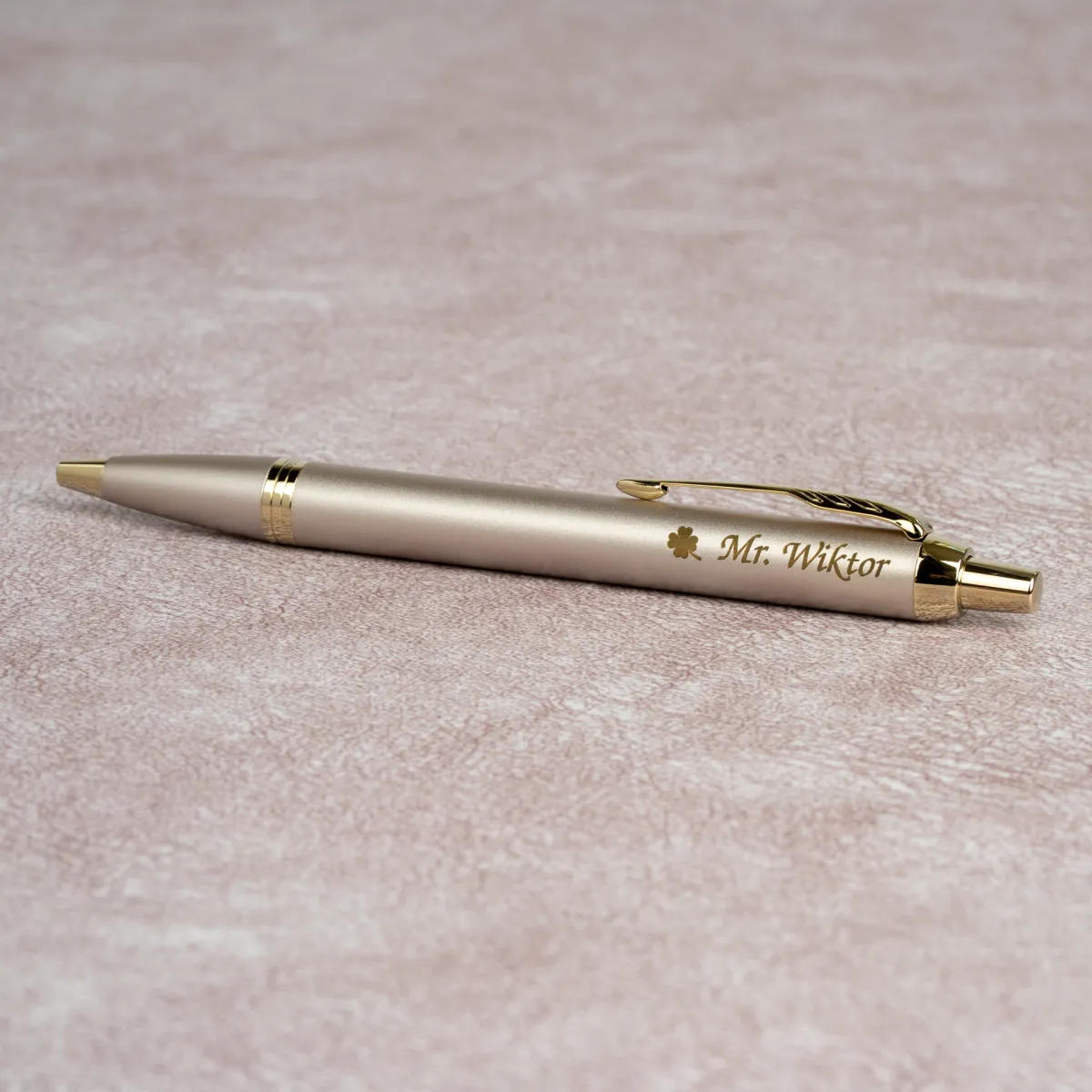 Personalizowany długopis Parker IM Professionals Monochrome Champagne z grawerem imienia i ozdobnym symbolem koniczyny na korpusie.