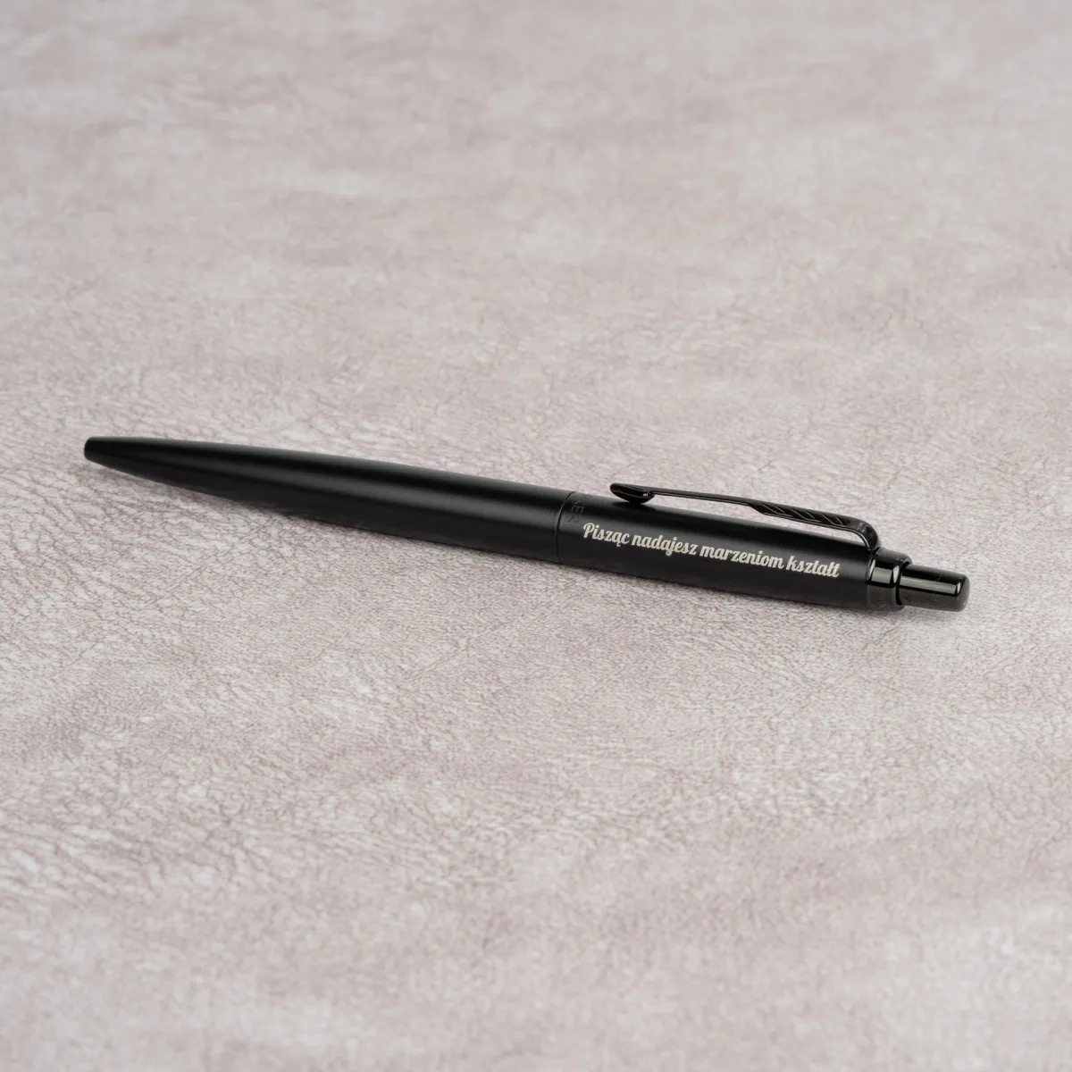 Długopis Parker Jotter XL Monochrome Black z grawerem na czarnym matowym korpusie i czarnymi wykończeniami.