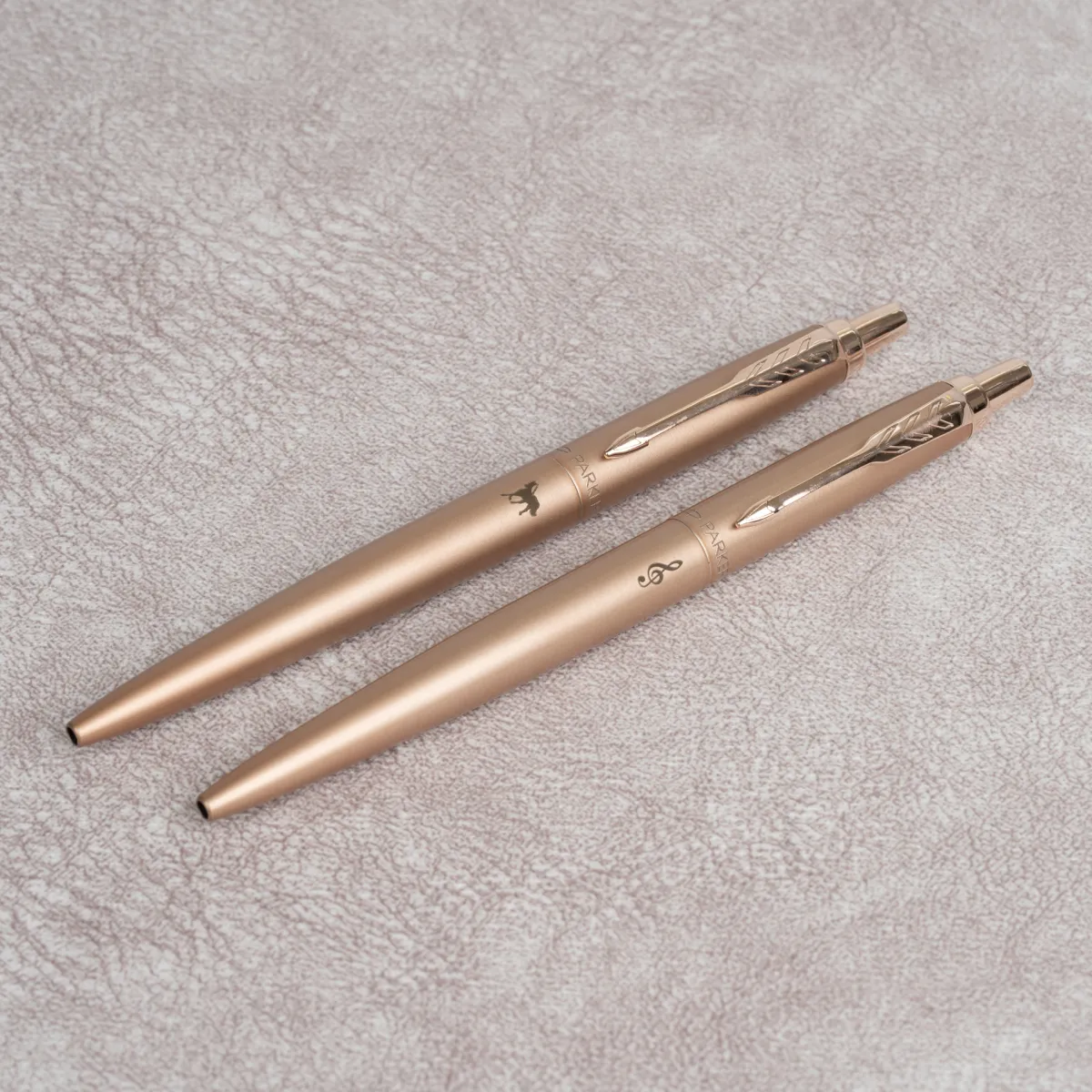 Dwa długopisy Parker Jotter XL Monochrome Pink Gold z indywidualnym grawerem na różowozłotym matowym korpusie.
