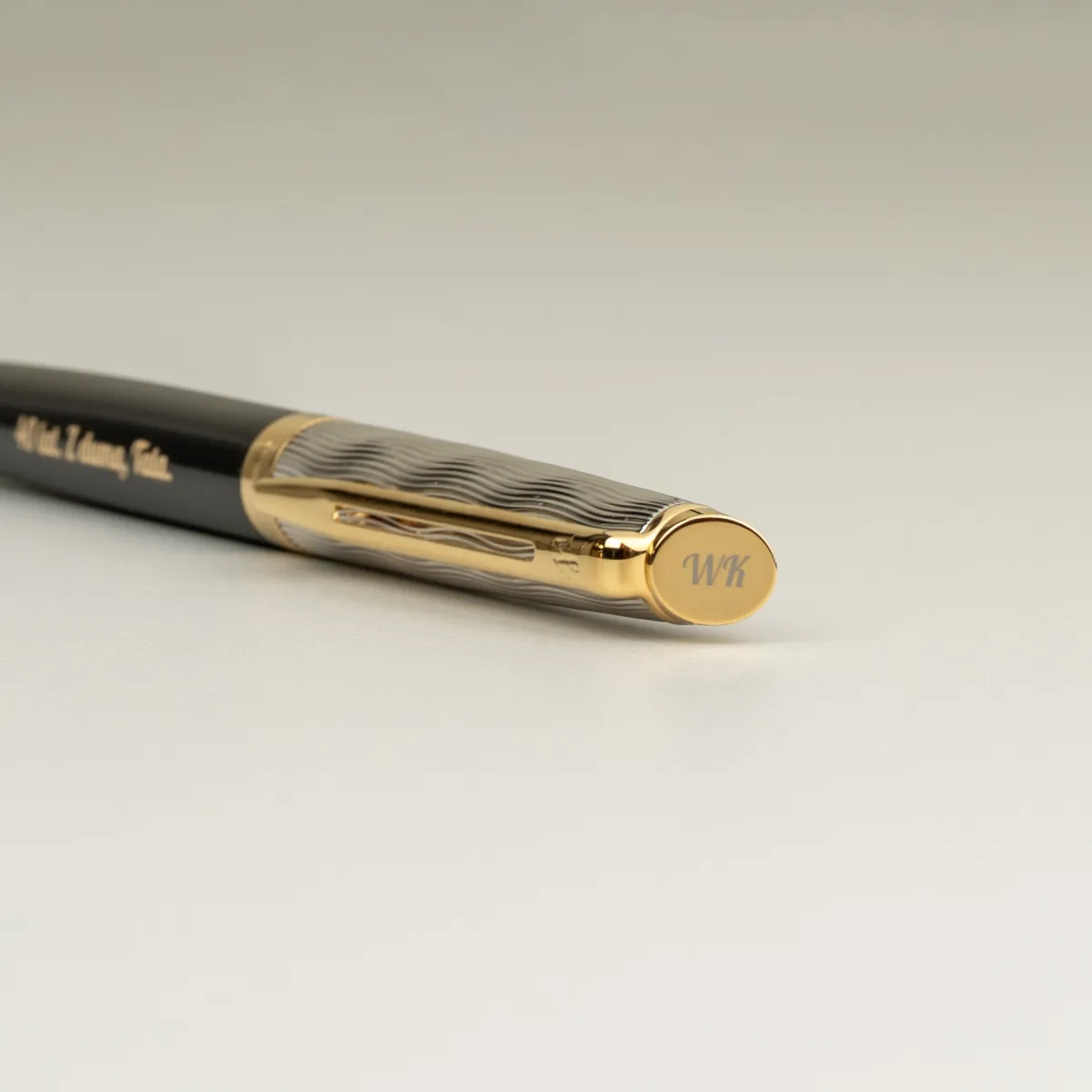 Zbliżenie na skuwkę długopisu Waterman Hemisphere Reflets De Paris GT [2200839] z grawerem inicjał&oacute;w &bdquo;WK&rdquo; na zakończeniu skuwki.