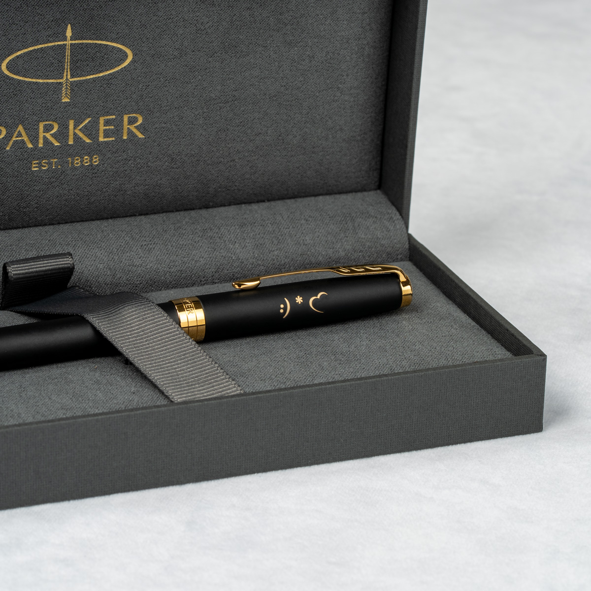 Długopis Parker Sonnet Czarny Matowy GT [1931519] z personalizowanym grawerem przedstawiającym uśmiechniętą buźkę, gwiazdkę i księżyc, w eleganckim pudełku Parker.